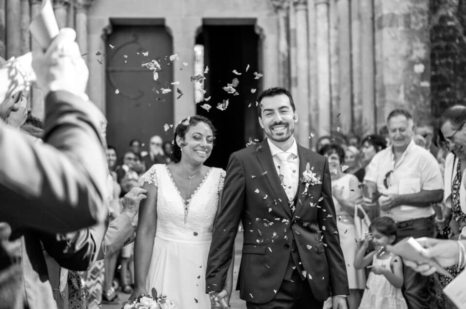 Mariage Flora & Benjamin, Sortie de la Basilique St Nazaire, Cité de Carcassonne, Aude. Jeunes mariés qui sortent de l'église sous une pluie de fleurs séchées