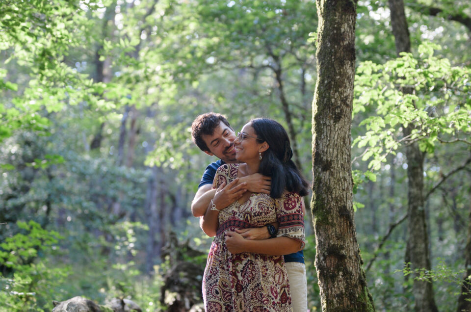 Séance photo de couple à la Rigole, dans la Montagne Noire. Ils sont enlacés dans les bras l'un de l'autre et se sourient.