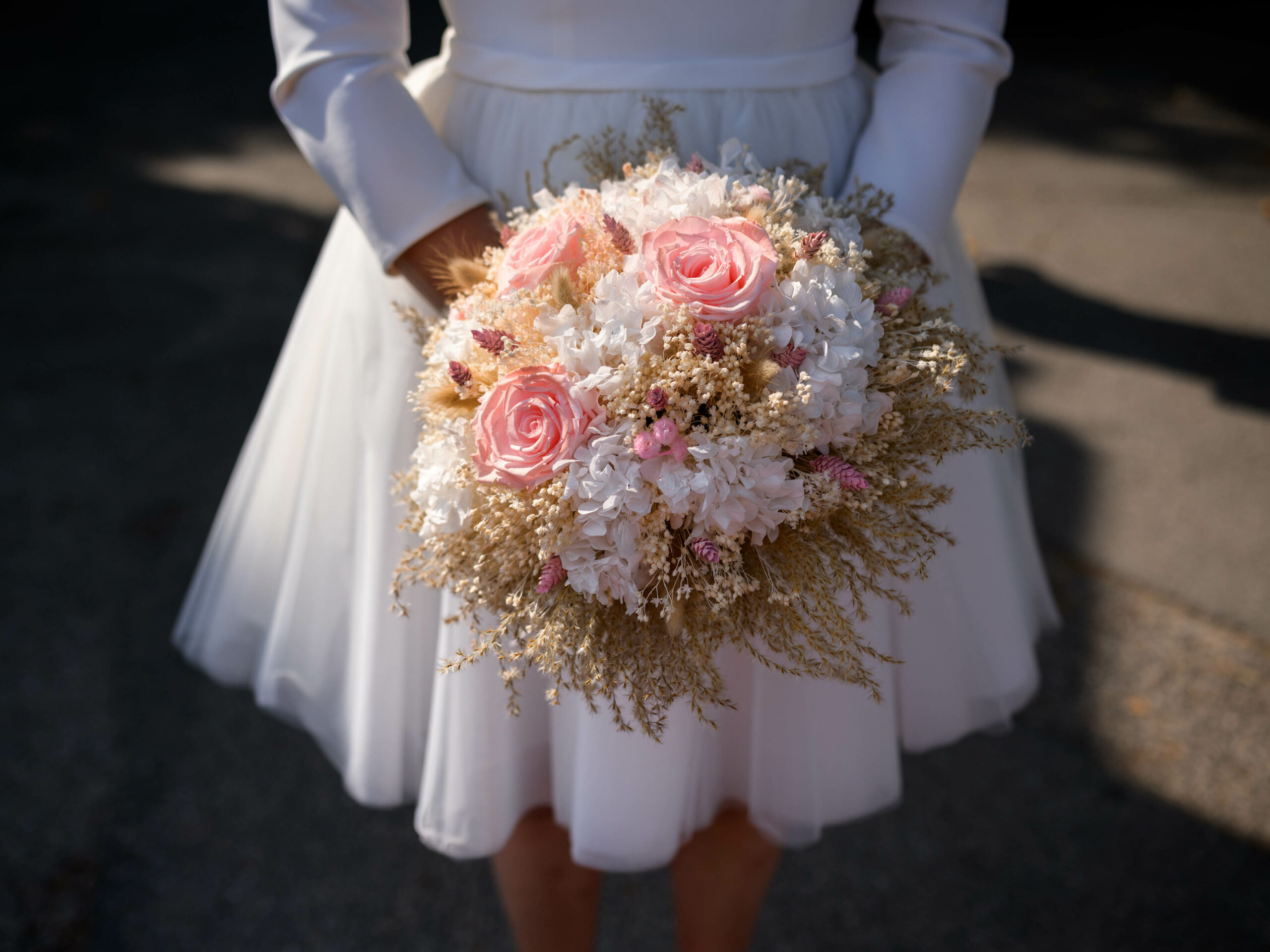 séance photo de couple mariage civil photo de détail du bouquet de la mariée réalisé en fleurs séchées et fleurs stabilisées. La mariée porte une robe courte Pronuptia pour mariage civil. Le bouquet est réalisé par Rose & Marguerite à Montolieu