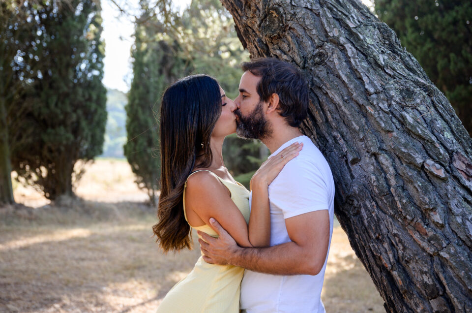 séance photo fiançailles, les futurs mariés sont l'un contre l'autre et ils s'embrassent jardin de la Chapelle Saint-Mamès, Villeneuve-Minervois, Aude