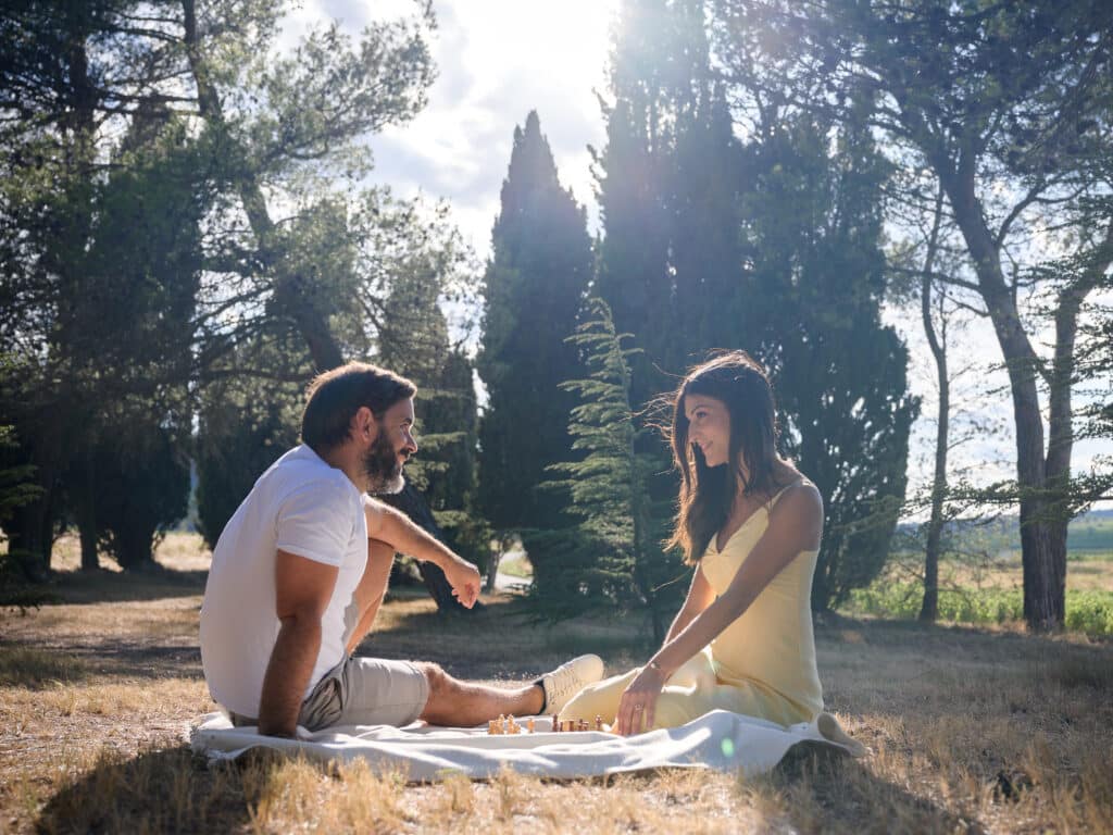 séance photo fiançailles, les futurs mariés jouent aux échecs jardin de la Chapelle Saint-Mamès, Villeneuve-Minervois, Aude